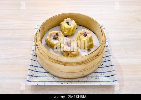 Un primo piano di deliziosi gnocchi di shumai cinesi su un cestino di bambù xiaolong Foto Stock