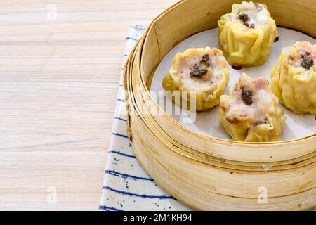 Un primo piano di deliziosi gnocchi di shumai cinesi su un cestino di bambù xiaolong Foto Stock