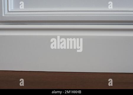 Parete opaca, baseboard bianco e piastrelle Foto Stock