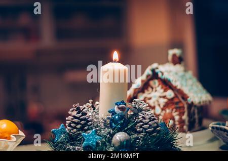 candela bruciante sulla decorazione di natale e casa di pan di zenzero Foto Stock