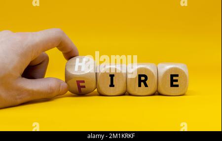 Scelta difficile. La mano capovolge i cubi di legno con fuoco di parola per assumere su uno sfondo grigio. Gestione e processi per il successo aziendale Foto Stock