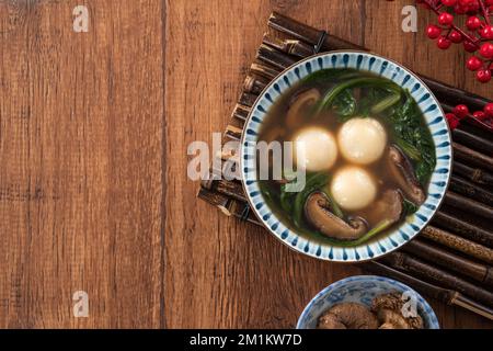 Mangiare il grande tangyuan yuanxiao (tang yuan, palle glutinose di riso gnocchi) con una zuppa saporita in una ciotola per il festival del solstizio d'inverno. Foto Stock