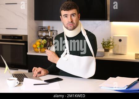 Lavoratore che fa l'ufficio domestico dopo un incidente Foto Stock