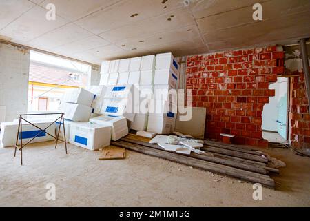 Confezioni di materiale termoisolante, Styrofoam, avvolti in foglio in attesa di essere installati sulle pareti, sistemati nel magazzino. Foto Stock