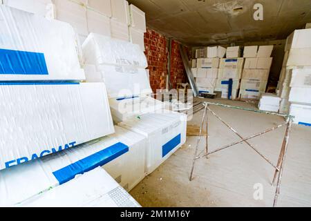 Confezioni di materiale termoisolante, Styrofoam, avvolti in foglio in attesa di essere installati sulle pareti, sistemati nel magazzino. Foto Stock