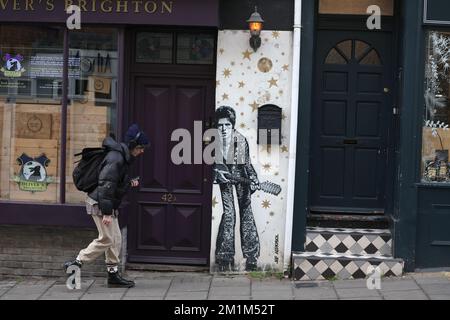 Un uomo passa davanti a un murale di David Bowie dipinto dall'artista JEF AEROSOL nella zona del Nord Laine di Brighton. Foto Stock