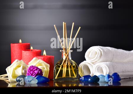 Diffusore aromatico a lamelle con fiori e pietra sul tavolo Foto Stock