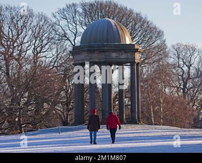 Edimburgo, Scozia, Regno Unito. 13th dicembre 2022. I residenti si sono svegliati al congelamento meno 7 gradi centigradi nella capitale scozzese, brina pesante ieri e oggi facendo per condizioni molto ghiacciate. Due uomini più anziani passeggiando attraverso il campo da golf di Duddingston, altrimenti abbandonato, con il monumento sullo sfondo. Credit: ArchWhite/alamy live news Foto Stock