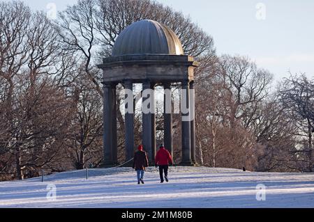 Edimburgo, Scozia, Regno Unito. 13th dicembre 2022. I residenti si sono svegliati al congelamento meno 7 gradi centigradi nella capitale scozzese, brina pesante ieri e oggi facendo per condizioni molto ghiacciate. Due uomini più anziani passeggiando attraverso il campo da golf di Duddingston, altrimenti abbandonato, con il monumento sullo sfondo. Credit: ArchWhite/alamy live news Foto Stock