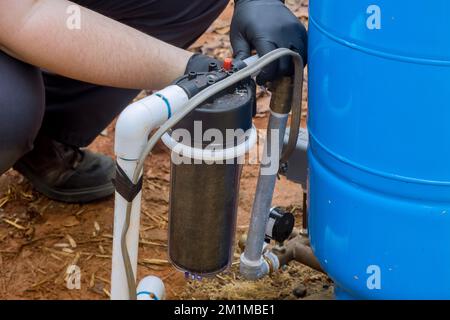 Al fine di mantenere l'acqua pulita all'esterno della casa, i lavoratori professionisti sostituiscono regolarmente i filtri sostituibili Foto Stock