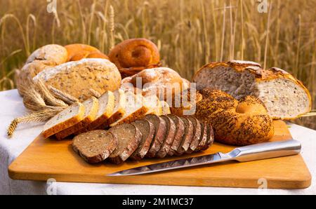 lotto di pane, grano, segale aromatizzato, sulla tavola all'esterno del campo Foto Stock