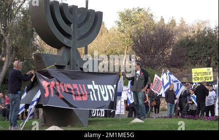 GERUSALEMME, ISRAELE - DICEMBRE 12: Gli attivisti di sinistra appendono una bandiera che recita "governo criminale” durante una manifestazione contro la coalizione di governo entrante negoziata da Benjamin Netanyahu davanti al Parlamento israeliano. Credit: Eddie Gerald/Alamy Live News Foto Stock