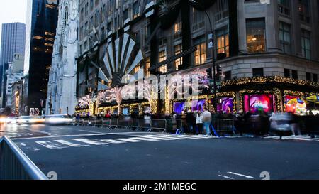 NEW YORK, NY, Stati Uniti d'America - 10 DICEMBRE 2022: Vista dalla trafficata avenue 5th vicino al negozio Saks decorato con luci Foto Stock