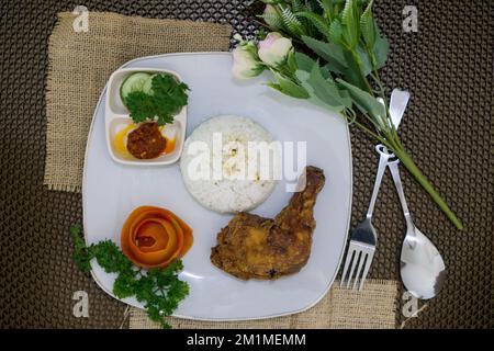 Cibo indonesiano fatto in casa, burro di pollo con riso bianco, verdure, pomodori e salsa al peperoncino Foto Stock