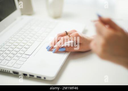 Donna che digita sulla tastiera del notebook in ufficio. Primo piano donna mani scrivere sulla tastiera di un computer portatile. casa, freelance, progetto, scrittura Foto Stock