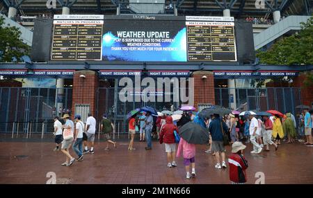 20120827 - NEW YORK, STATI UNITI: L'illustrazione mostra gli spettatori coperti dalla pioggia il primo giorno del torneo di tennis US Open Grand Slam, a Flushing Meadows, a New York City, USA, lunedì 27 agosto 2012. FOTO DI BELGA YORICK JANSENS Foto Stock