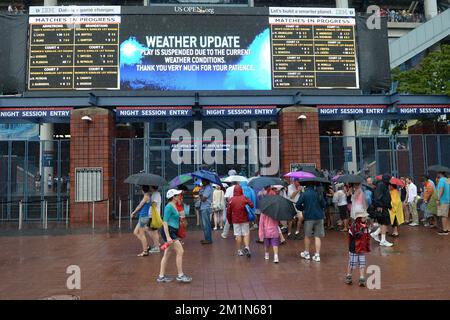 20120827 - NEW YORK, STATI UNITI: L'illustrazione mostra gli spettatori sotto la pioggia il primo giorno del torneo di tennis US Open Grand Slam, a Flushing Meadows, a New York City, USA, lunedì 27 agosto 2012. FOTO DI BELGA YORICK JANSENS Foto Stock