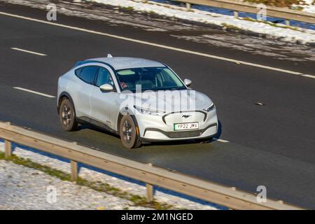 2022 White FORD MUSTANG MACH-e STD GAMMA RWD; auto che viaggiano su una fredda mattina invernale. Inverno basse temperature con gelo a dicembre e condizioni di guida fredde sull'autostrada M61, Regno Unito Foto Stock