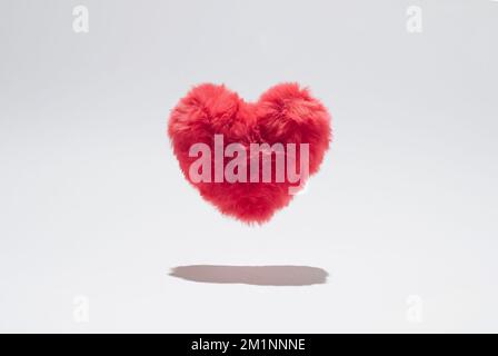 Cuore morbido rosa che si levita sopra lo sfondo bianco. Foto Stock