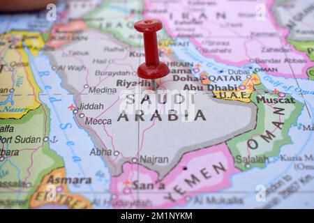 Puntino rosso che indica la posizione dell'Arabia Saudita primo piano della mappa mondiale Visualizza la fotografia d'archivio Foto Stock