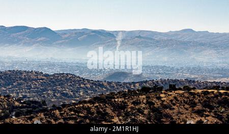 Polvere e fumo si depositano nelle valli sopra Windhoek in una mattinata ferma e fredda. Foto Stock