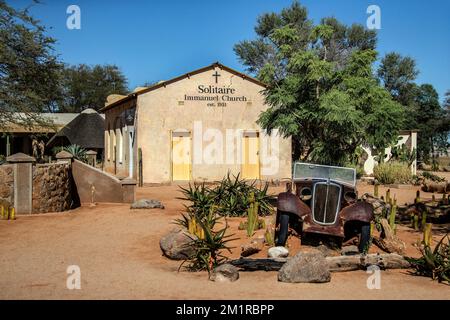 Un'auto vecchia di fronte alla Chiesa dell'Immanuele a Solitaire nel deserto del Namib. Foto Stock