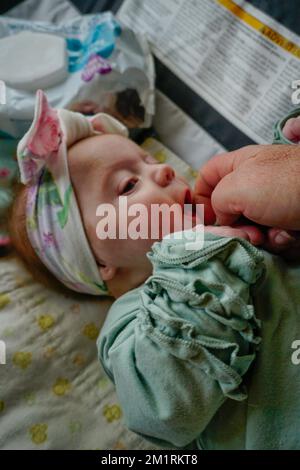 Bambino di 2 settimane che esibita una Reflex radente quando il viso è stroked. Foto Stock