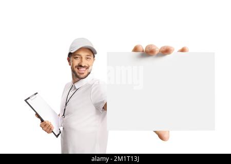 Allenatore sportivo con un fischio che tiene in mano una clipboard e mostra una carta bianca isolata su sfondo bianco Foto Stock
