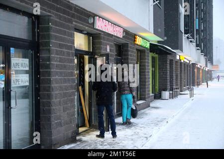 San Pietroburgo, Russia. 12th Dec, 2022. Le persone entrano nel negozio durante una pesante nevicata e Blizzard portato dal ciclone Birgit a St. Pietroburgo. (Credit Image: © Konstantinov/SOPA Images via ZUMA Press wire) Foto Stock
