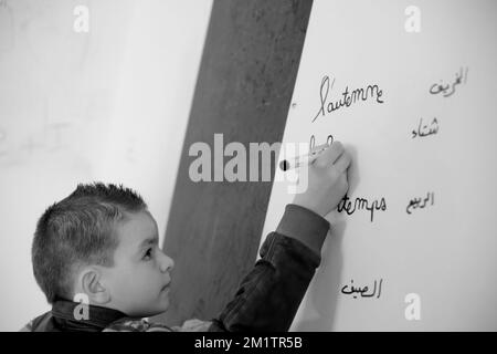 20140122 - VALLE DI BEKAA, LIBANO: I rifugiati siriani di guerra cercano di farlo nella valle di Bekaa. Oggi ci sono più di 700.000 siriani rifugiati dalla guerra nella valle del Libano Bekaa. Nella foto: I bambini siriani imparano il francese in una scuola libanese ad al-Ain. Foto Stock