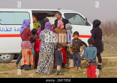 20140122 - VALLE DI BEKAA, LIBANO: I rifugiati siriani di guerra cercano di farlo nella valle di Bekaa. Oggi ci sono più di 700.000 siriani rifugiati dalla guerra nella valle del Libano Bekaa. Sulla foto: I siriani ricevono assistenza medica da un furgone mobile della clinica dispiegato da Amel, una ONG attiva nella pianura di al-Ain per aiutare i rifugiati. Foto Stock