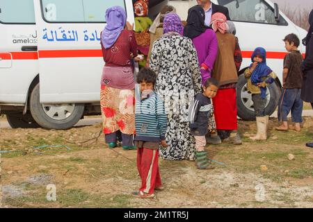 20140122 - VALLE DI BEKAA, LIBANO: I rifugiati siriani di guerra cercano di farlo nella valle di Bekaa. Oggi ci sono più di 700.000 siriani rifugiati dalla guerra nella valle del Libano Bekaa. Sulla foto: I siriani ricevono assistenza medica da un furgone mobile della clinica dispiegato da Amel, una ONG attiva nella pianura di al-Ain per aiutare i rifugiati. Foto Stock