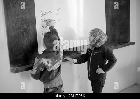 20140122 - VALLE DI BEKAA, LIBANO: I rifugiati siriani di guerra cercano di farlo nella valle di Bekaa. Oggi ci sono più di 700.000 siriani rifugiati dalla guerra nella valle del Libano Bekaa. Nella foto: I bambini siriani imparano il francese in una scuola libanese ad al-Ain. Foto Stock