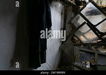 Un vecchio vestito e elementi arrugginiti all'interno di una casa abbandonata nella zona di esclusione nucleare di Cernobyl Foto Stock