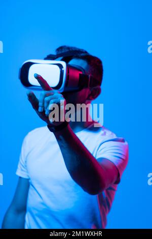 Uomo che indossa occhiali VR virtuali. Giovane uomo portatore che indossa cuffie per realtà virtuale. Concetto di realtà virtuale. Foto Stock