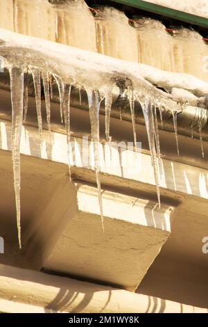 Grandi ghiaccioli sul bordo del tetto Foto Stock