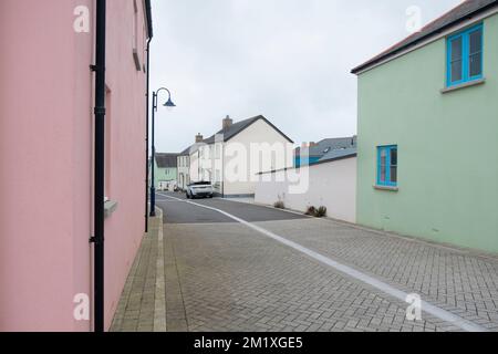 Case verdi e rosa lungo Bownder Tennyson, una strada a Nansledan, uno sviluppo del Ducato di Cornovaglia a Newquay, Cornovaglia, Inghilterra sud-occidentale, Regno Unito Foto Stock