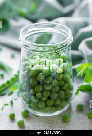 Barattolo con giovani cialde fresche e succose di piselli verdi. Cibo biologico sano. Foto Stock