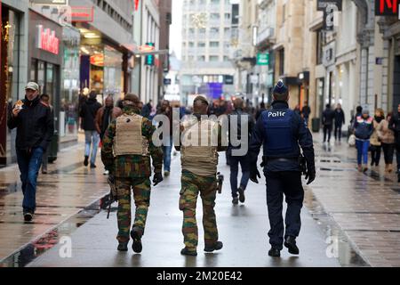 20151121 - BRUXELLES, BELGIO: L'illustrazione mostra gli ufficiali di polizia e militari che pattugliano nella Nieuwstraat/Rue Neuve , sabato 21 novembre 2015, a Bruxelles. Il livello di minaccia è stato aggiornato al livello quattro, il massimo, nella regione di Bruxelles, e rimane al livello tre per il resto del paese. Il centro commerciale, le principali vie dello shopping, le metropolitane e gli eventi pubblici sono chiusi e annullati per il fine settimana a causa della minaccia terroristica di livello quattro. FOTO DI BELGA NICOLAS MAETERLINCK Foto Stock