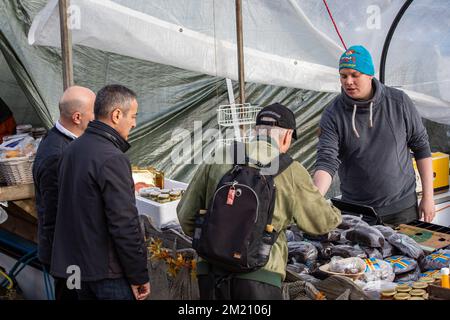Venditore di prodotti correlati all'aringa baltica e pane nero da barca alla tradizionale fiera dell'aringa baltica o Silakkamarkkinat a Helsinki, Finlandia Foto Stock