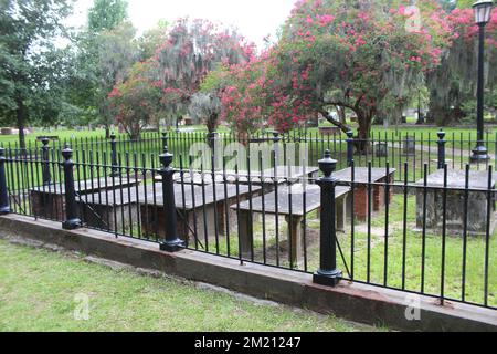 Tombe al cimitero del parco coloniale di Savannah, Georgia, con alberi di mirto cremoso e muschio spagnolo sullo sfondo Foto Stock