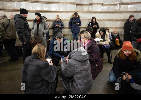 Kiev, Ucraina. 13th Dec, 2022. Le persone con smartphone trascorrono del tempo all'interno di una stazione della metropolitana durante un allarme RAID aereo nel centro di Kiev. I civili usano le stazioni della metropolitana di Kyiv come rifugio durante le incursioni aeree. (Foto di Oleksii Chumachenko/SOPA Image/Sipa USA) Credit: Sipa USA/Alamy Live News Foto Stock