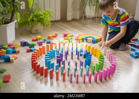 Carino maschio capretto costruzione legno edificio colorato cubo blocco Montessori materiale giocare a casa Foto Stock