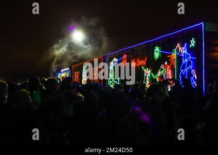 La gente guarda l'arrivo del treno canadese Pacifico ora di Natale, l'illuminazione al neon sulle vetture del treno. Il Train organizza un concerto di beneficenza per vari tipi di carattere Foto Stock