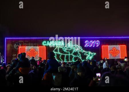 La gente guarda l'arrivo del treno canadese Pacifico ora di Natale, l'illuminazione al neon sulle vetture del treno. Il Train organizza un concerto di beneficenza per vari tipi di carattere Foto Stock