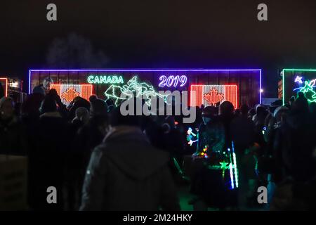 La gente guarda l'arrivo del treno canadese Pacifico ora di Natale, l'illuminazione al neon sulle vetture del treno. Il Train organizza un concerto di beneficenza per vari tipi di carattere Foto Stock