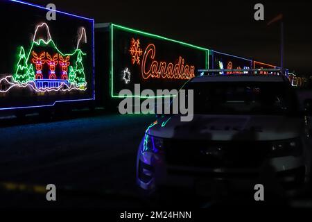 La gente guarda l'arrivo del treno canadese Pacifico ora di Natale, l'illuminazione al neon sulle vetture del treno. Il Train organizza un concerto di beneficenza per vari tipi di carattere Foto Stock