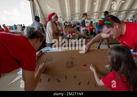 Yigo, Stati Uniti. 03 dicembre 2022. Volontari decorano le scatole del pacchetto in preparazione per la consegna durante l'operazione Christmas Drop 2022 alla base dell'aeronautica di Andersen, 3 dicembre 2022 a Yigo, Guam. Operazione Christmas Drop è la più antica missione umanitaria e di soccorso in caso di disastri che offre 71.000 chili di cibo, regali e forniture per assistere le comunità remote dell'isola nel Pacifico meridionale. Credit: Yasuo Osakabe/US Airforce Photo/Alamy Live News Foto Stock