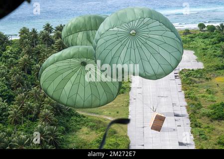 Ulithi Atoll, Stati Federati di Micronesia. 04 dicembre 2022. Fasci di carico discendono da un U.S.A. Air Force C-130J Hercules Aircraft on to Ulithi Airport durante l'operazione Christmas Drop 2022, 4 dicembre 2022 a Ulithi Atoll, Carolina Islands, FSM. Operazione Christmas Drop è la più antica missione umanitaria e di soccorso in caso di disastri che offre 71.000 chili di cibo, regali e forniture per assistere le comunità remote dell'isola nel Pacifico meridionale. Credit: Yasuo Osakabe/US Airforce Photo/Alamy Live News Foto Stock