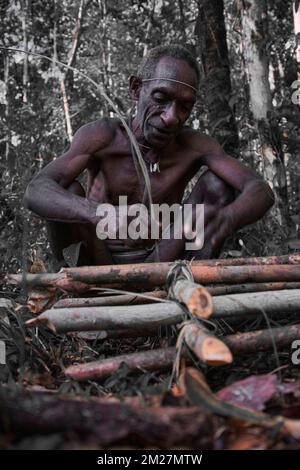 Fare trappole per suini per il popolo Korowai è una tradizione che è stata tramandata di generazione in generazione. Ancora una volta, le materie prime per questo occ Foto Stock